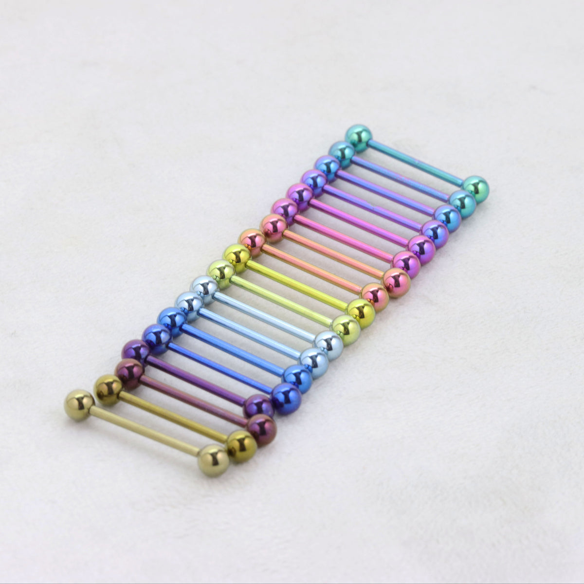 Colorful metallic barbell piercings on a white background suitable for tongue bars industrial bars eyebrow bars 